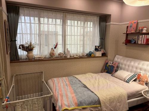愛子の部屋 寝室<br>やさしい⾊合いのケースメント「LS-63200」で、リビングと寝室をゆるやかに仕切る間仕切りとして活⽤。引けば空間がひとつにつながり、広がりを感じるワンルームに。どこか懐かしさを感じさせる表情が、インテリアのやさしいアクセントになる。またカーテンに合わせたタッセルの組み合わせにも、さりげないこだわりが光る。“こんな部屋に住んでみたい”と憧れる、⼼地よい住まいのかたち。