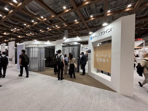 <b>●タチカワブラインド</b><br>「ゆるやかな空間をつくる」をテーマに初出展し、働き方の多様化が進む現代社会に合わせた間仕切りの新たな使い方や価値を提案。間仕切り製品を中心にオフィスや店舗、ホテルなどでの活用方法を紹介。商品としては5月に発売した間仕切「プレイス」移動収納下荷重仕様を展示し、システム天井や軽量鉄骨下地など、天井裏の強度を十分に確保しにくい施工条件においても導入しやすく、既存施設の改装やテナント入居後のレイアウト変更にも柔軟に対応できることなどを訴求した。