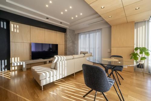 ● 第２位 『ラグジュアリーモダン×和、ホテルライクな暮らし』……中古マンションだからこそ手に入れられた、十分な広さと大きなルーフバルコニーを備えた物件をホテルライクにリノベーションした事例。生活動線の良い３LDKの間取りや折り上げ天井など既存の部分も活かしながら、リノベーションにより内装デザインを一新。キッチンの背面には和モダンなホテルをイメージした木の縦格子をあしらい、ひとつの家具のような存在感を出している。玄関や廊下、洗面室、キッチンの天井や壁は、グレーのタイルや黒のクロスを締め色として採用し、明暗のメリハリある空間に仕上げられている。